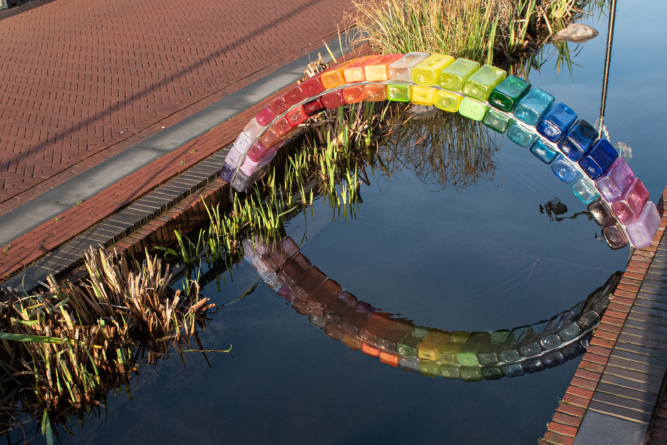 Glazen regenboog kunstwerk over de Jansbeek
