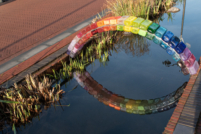 Glazen regenboog kunstwerk over de Jansbeek